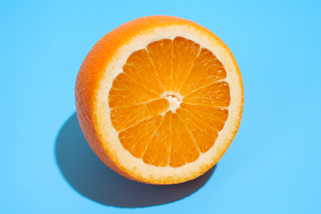 Ripe juicy delicious orange on blue background. Healthy eating and dieting conceptの写真素材
