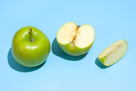 Ripe parts green apple Isolated on a blue background. Healthy eating and dieting conceptの写真素材
