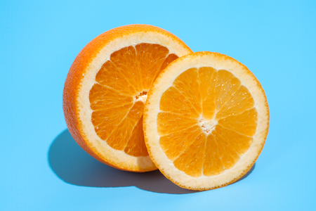 Ripe juicy delicious orange on blue background. Healthy eating and dieting conceptの写真素材