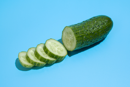 Ripe green cucumber on blue background. Healthy eating and dieting conceptの写真素材