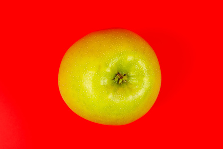 tasty organic green delicious apple, healthy eating and dieting concept, isolated on red backgroundの写真素材