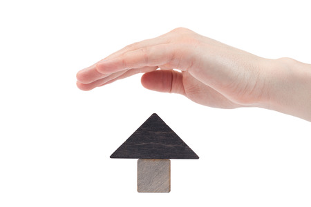 Wooden house toy blocks isolated white background. The concept of buying and selling real estate, rental housing, Home protection, Home protection. Affordable housing, investment and construction.の写真素材