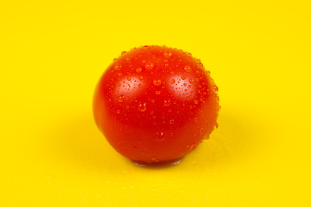 Fresh red tomato isolated on yellow background.の写真素材