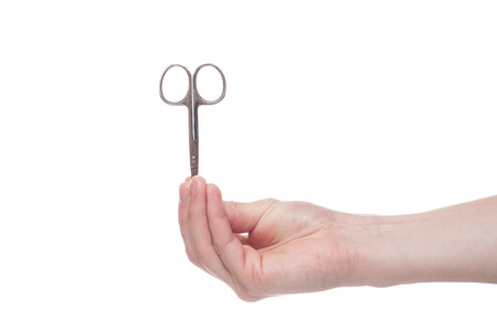 Hand holding scissors for manicure isolated on white background. Health and personal care conceptionの写真素材