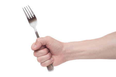 hand holding a silver fork on an isolated white backgroundの写真素材