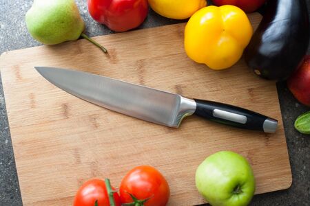 Still life of vegetables and kitchen-knife on cutting boardの写真素材