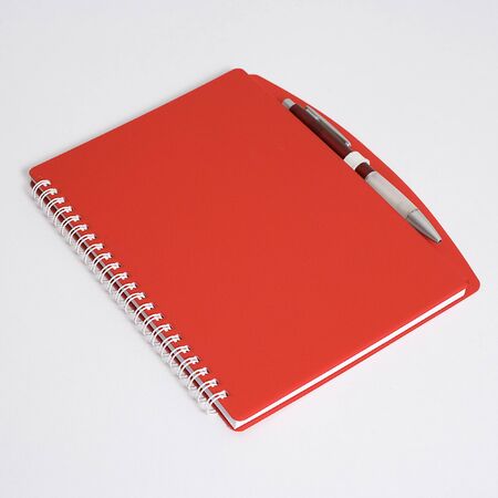 Red notebook with pen isolated on whiteの写真素材