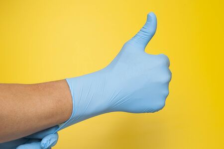 Doctor hand with glove showing like gesture or thumbup as approval, accept or done conceptの写真素材