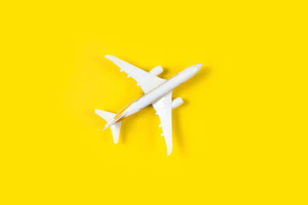 model of passenger plane on yellow background. Flat lay travel concept design. Copy space