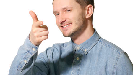 Young handsome man over isolated background happy with big smile doing ok sign, thumb up with fingers, likeの写真素材