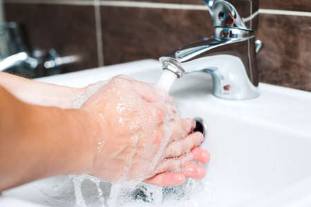 Hygiene concept. Washing hands with soap under the faucet with waterの写真素材
