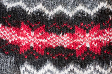 Gray mittens with pattern on a asphalt. Lost mitten