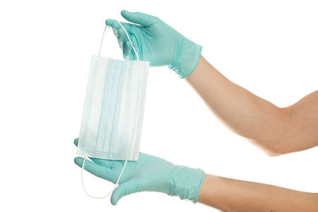 close up of doctor's hand in blue gloves with a medical face mask for protection against infection on white background. Covid. Coronavirusの写真素材