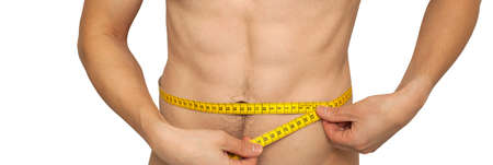 Fit man measuring his waist after a workout in the gym, isolated on a white background. Fitnes...