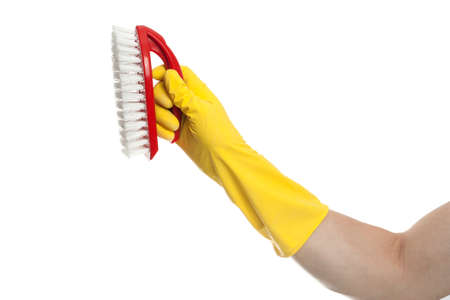Hand in yellow glove with a red cleaning brush on a white background. Home cleaning conceptの写真素材