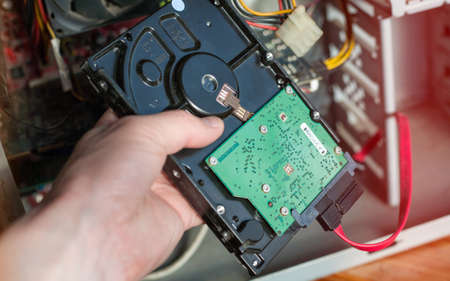 A technician repairing a computer with different tools. Computer support engineer changing the hard drive of an office Computer.の写真素材