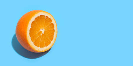 Ripe juicy delicious orange on blue background. Healthy eating and dieting conceptの写真素材
