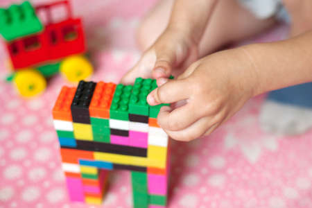 Small hands of the child collects the bright plastic colored Designer. Educational toys and Early learningの写真素材
