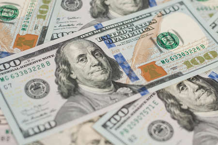 100 Dollars bill and portrait Benjamin Franklin on USA money banknote. Hundred dollar bills on wooden background.の写真素材