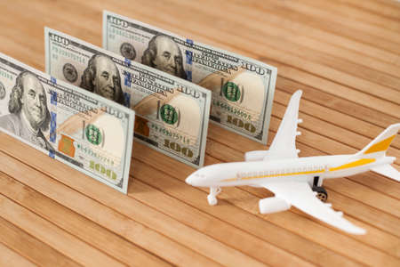 Plane model, face mask and and US dollars money on a wooden background with copy space. resumption of flights. opening of international flights after concept of coronavirus (COVID-19).の写真素材