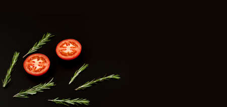 Fresh slices tomato and rosemary isolated on a black background. Herbs and spices. Food Ingredients, top viewの写真素材