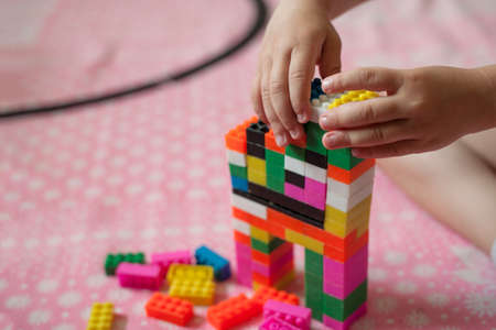 Small hands of the child collects the bright plastic colored Designer. Educational toys and Early learningの写真素材