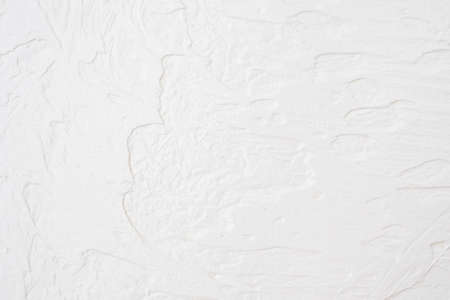 The texture of the white concrete table. White painted texture with brush and palette knife strokes for interesting and modern backgrounds.の写真素材