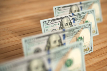100 Dollars bill and portrait Benjamin Franklin on USA money banknote. Hundred dollar bills on wooden background.の写真素材