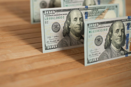 100 Dollars bill and portrait Benjamin Franklin on USA money banknote. Hundred dollar bills on wooden background.の写真素材
