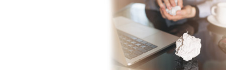 Businessman crumpling paper on his workplace Office workplace with crumpled paper balls on the tableの写真素材