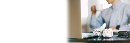 Man in blur, laptop, coffee cup and crumpled wads on table. new ideaの写真素材