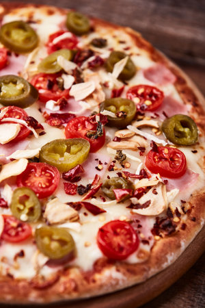 Pizza with ham, cheese and jalapeno pepper on wooden backgroundの写真素材