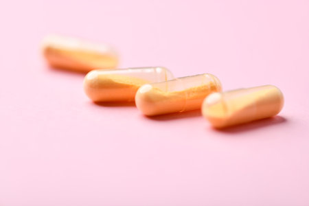 Capsules of omega 3 fish oil on a pink background.の写真素材