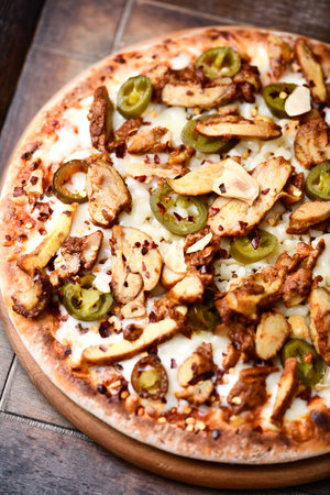 Pizza with mushrooms, cheese and olives on a wooden tableの写真素材