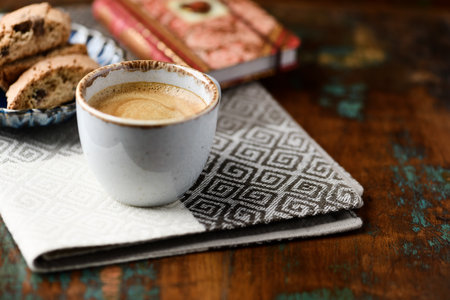 Cup of coffee and cookies on napkin on old wooden backgroundの写真素材
