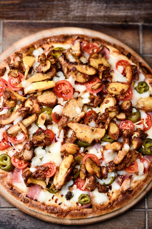 Pizza with meat and vegetables on wooden background. Selective focus.の写真素材