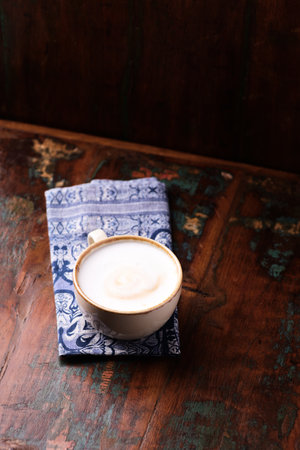 Coffee cup with saucer on blue napkin on old wooden backgroundの写真素材