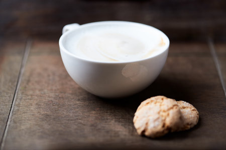 Cup of cappuccino with cookies on wooden table.の写真素材