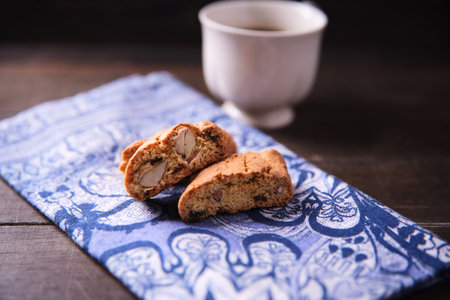 Cantuccini cookies on napkin and cup of coffee on wooden backgroundの写真素材