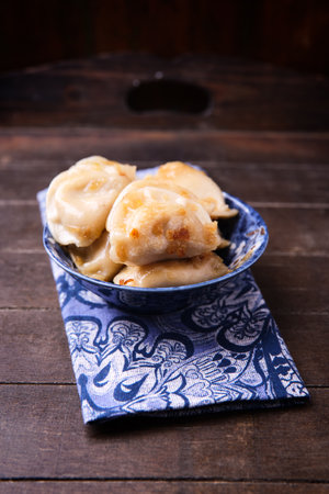 Fried dumplings in a blue plate on a wooden backgroundの写真素材