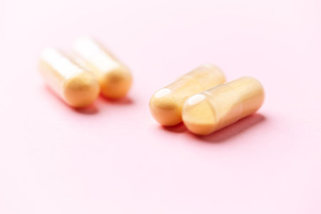 Capsules of omega 3 fish oil on a pink background.