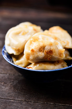Fried dumplings with meat on a wooden background. Selective focus.の写真素材