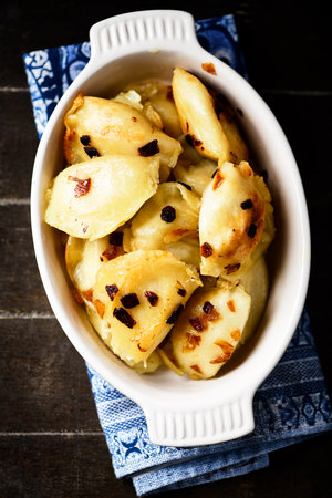 Fried potato dumplings with raisins in baking dishの写真素材