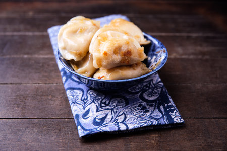 Fried dumplings in a blue bowl on a wooden backgroundの写真素材
