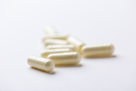 Close up of white capsules on white background. Focus on foreground.の写真素材