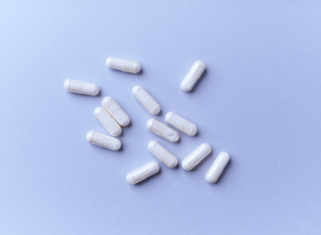 White pills on a blue background. Focus on foreground, soft bokeh.の写真素材