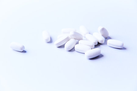 White pills on a white background. Focus on foreground, soft bokeh.の写真素材
