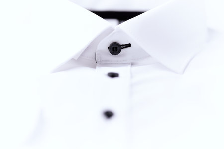 Close up of white shirt with black buttons isolated on white background.の写真素材