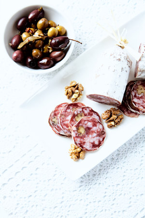 salami with olives and nuts on a white background. tinting. selective focusの写真素材