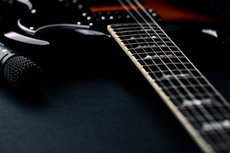 Electric guitar and microphone on a black background. Musical instrument. Close up.